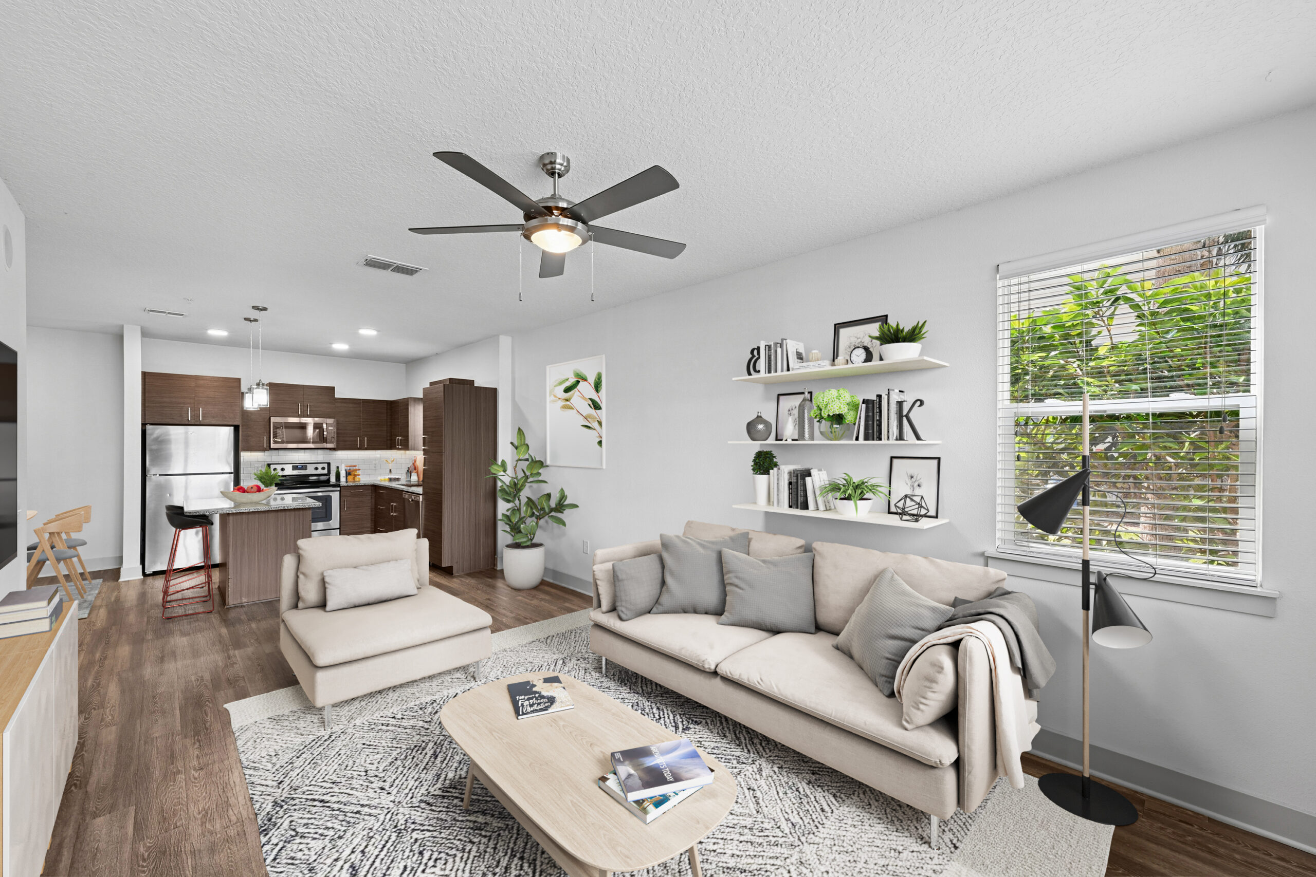 Large living space with natural lighting and ceiling fan