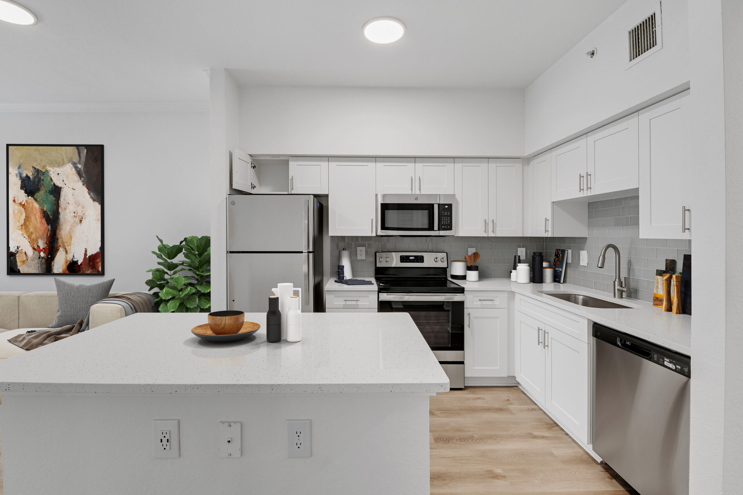 Spacious, open-concept kitchen with stainless steel appliances, granite countertops, and plank flooring