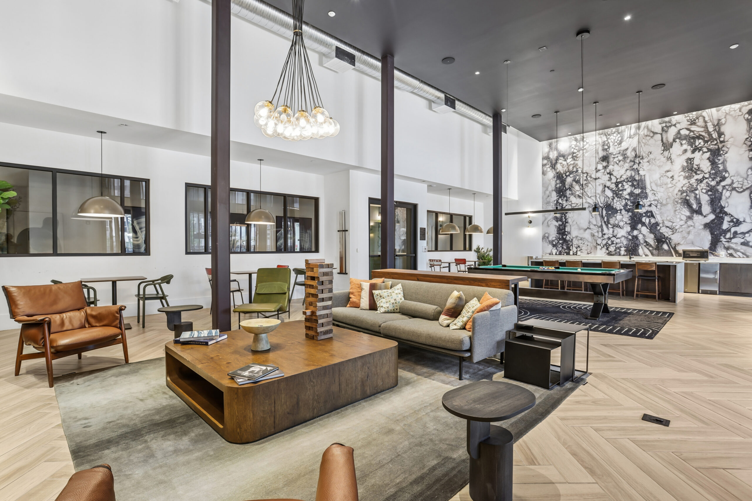 Tallulah resident clubroom with lounge seating, billiards, game tables, and a modern entertainment kitchen.