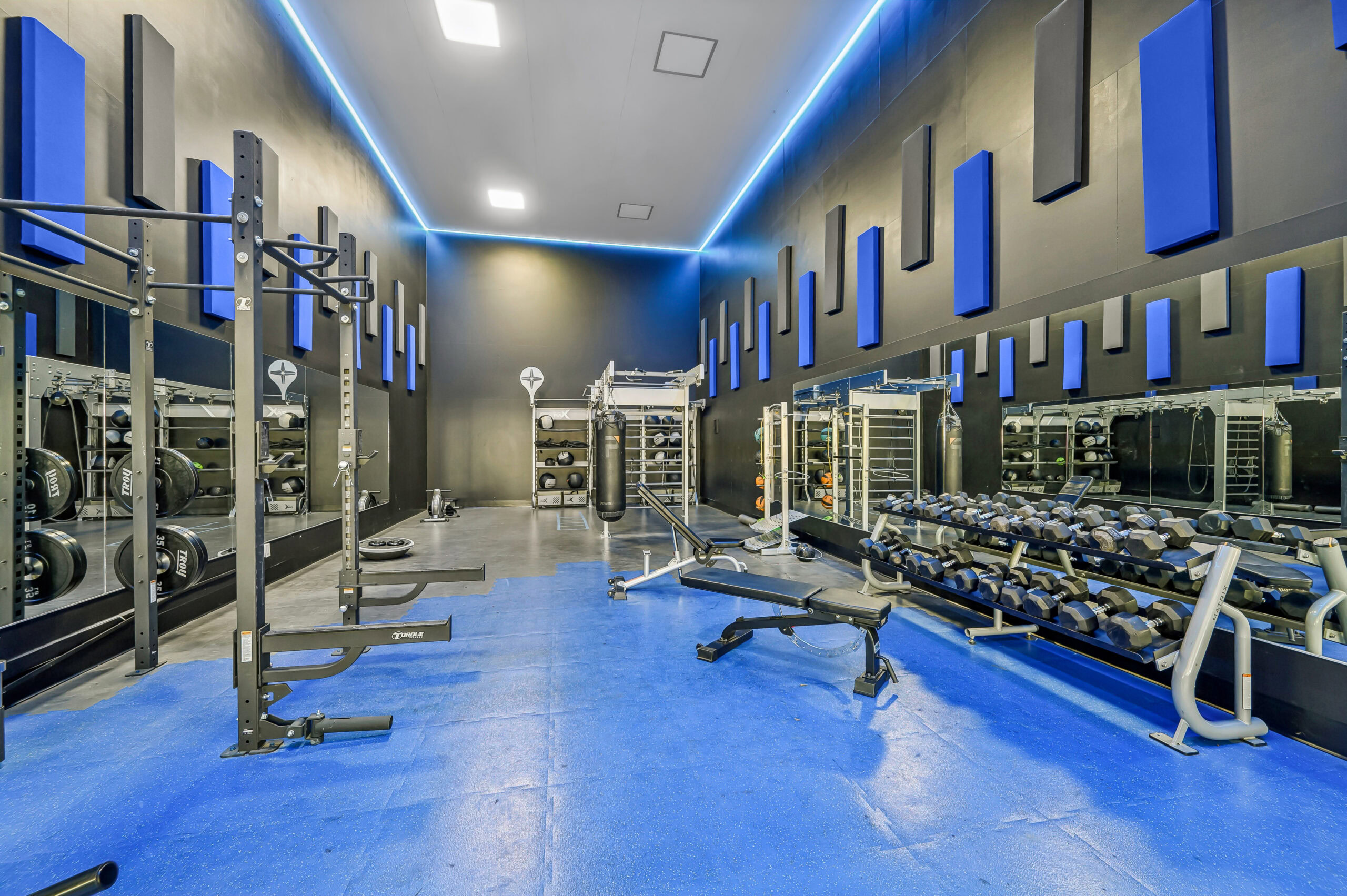 Functional training room at Vintage Pointe with blue exercise lanes, resistance stations, a training tire, and fitness equipment.