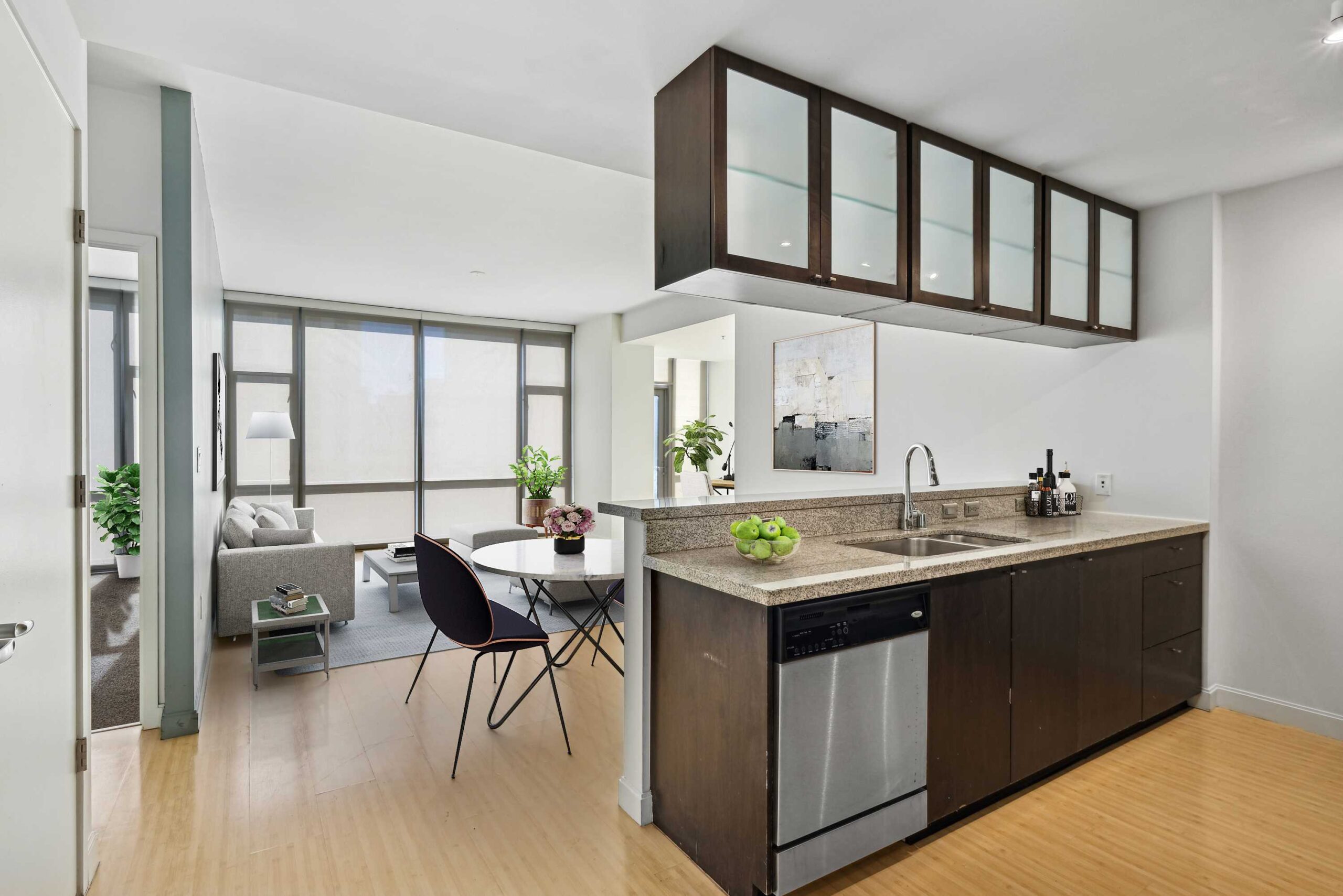 A modern, open plan apartment kitchen facing the living room and dining room space at The Elements luxury apartments in Dallas, Texas