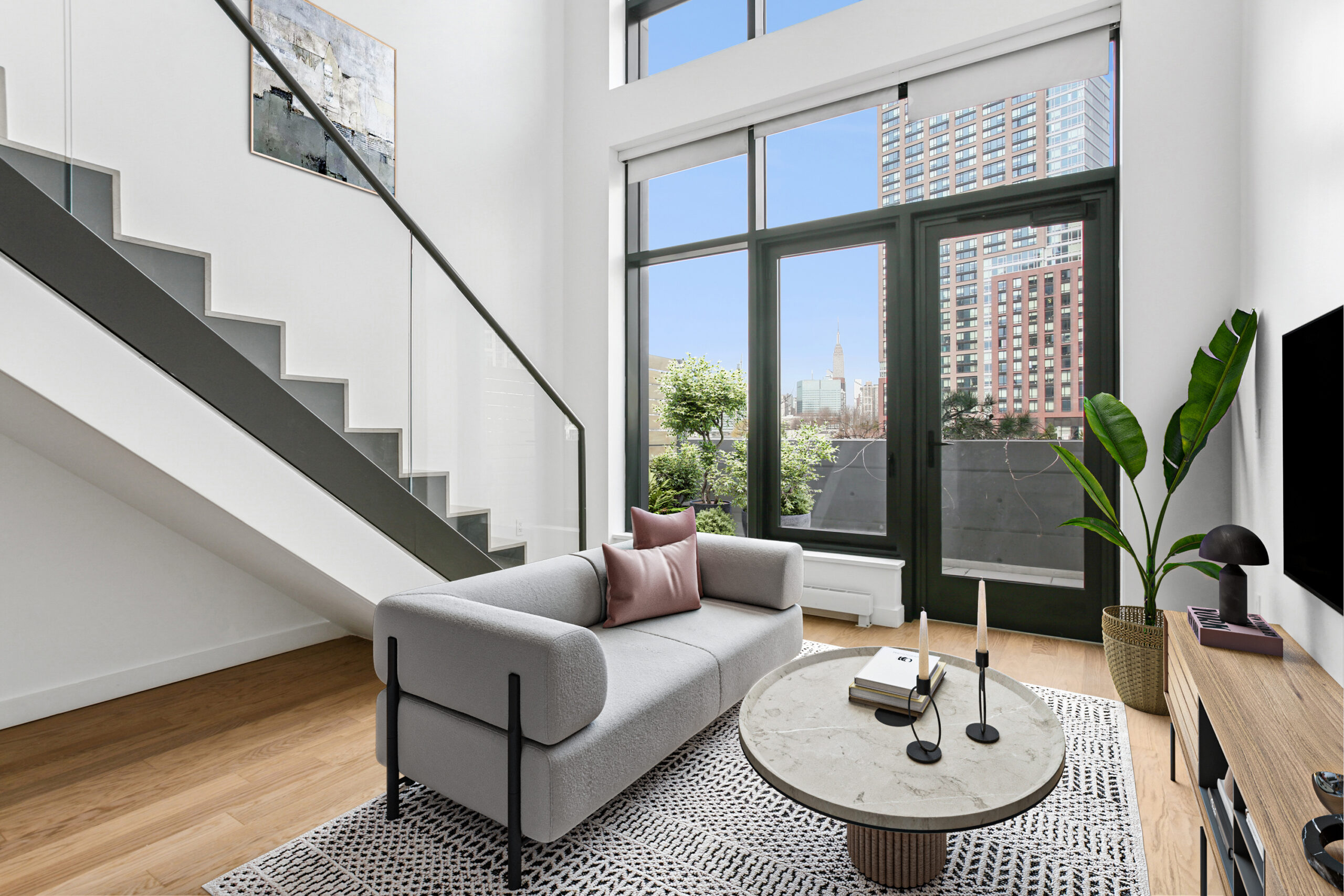 Living area with balcony and stairs leading to second level