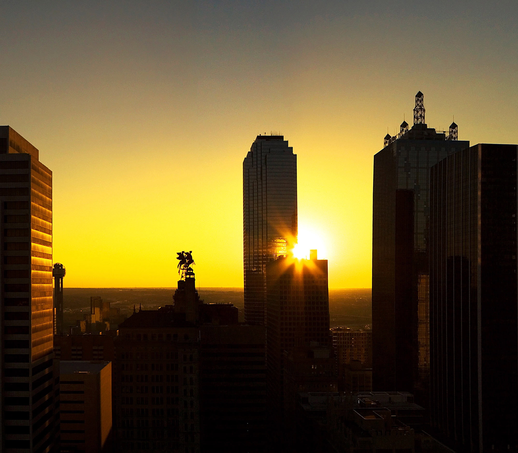 City views of the sun setting near The Merc in Mercantile Place apartments in Dallas Texas