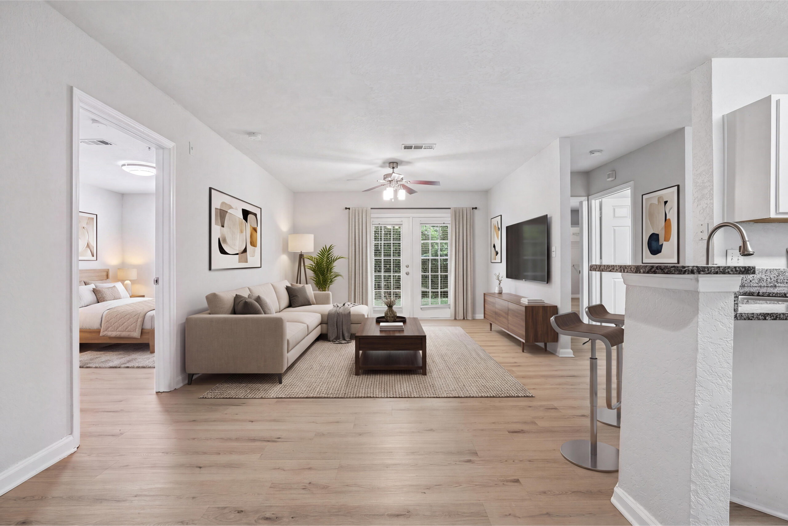 Spacious, open-concept living room with natural lighting, hardwood plank flooring, and modern features