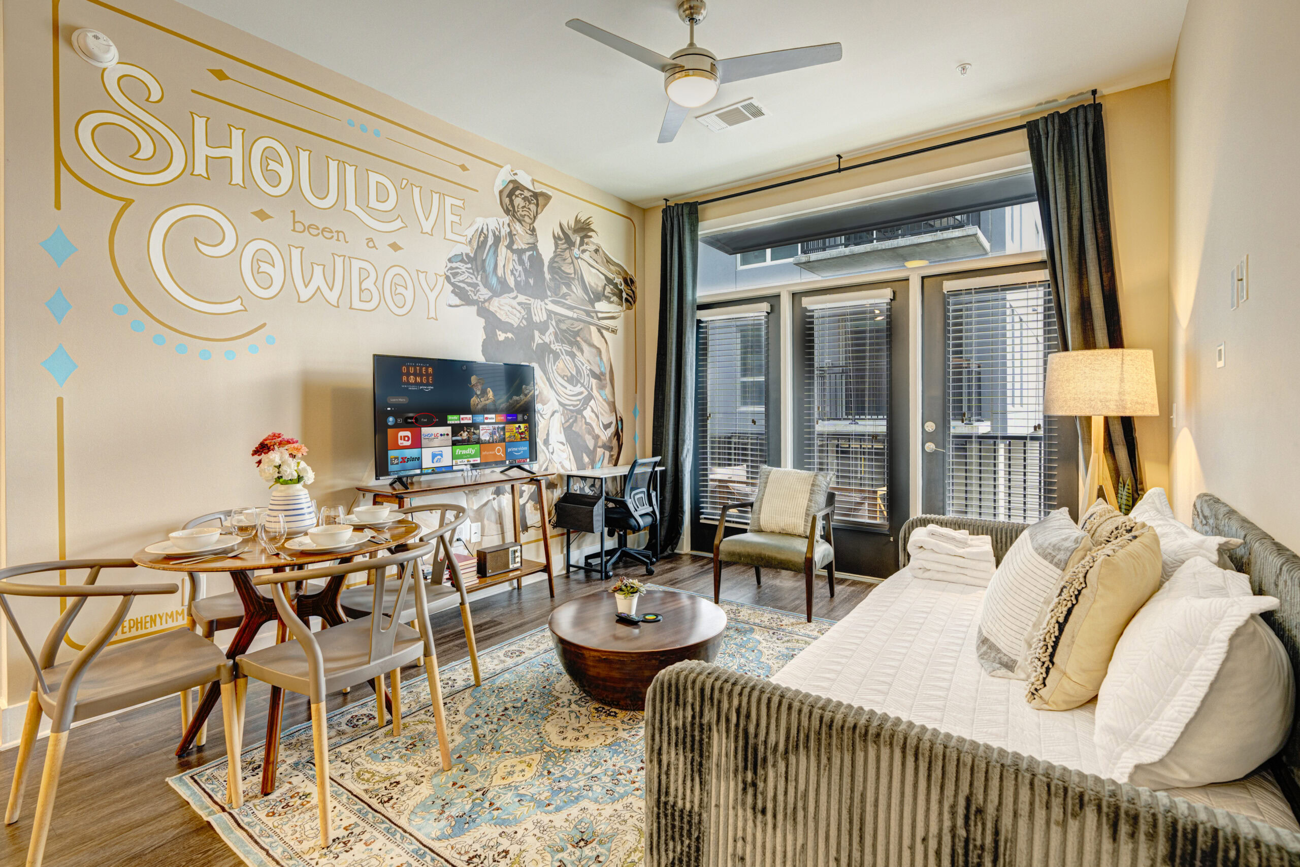 Themed decor of a short-term stay living room at The Burnham Nashville with modern furniture, large windows, and stylish decor, perfect for a vacation stay with friends in Nashville.
