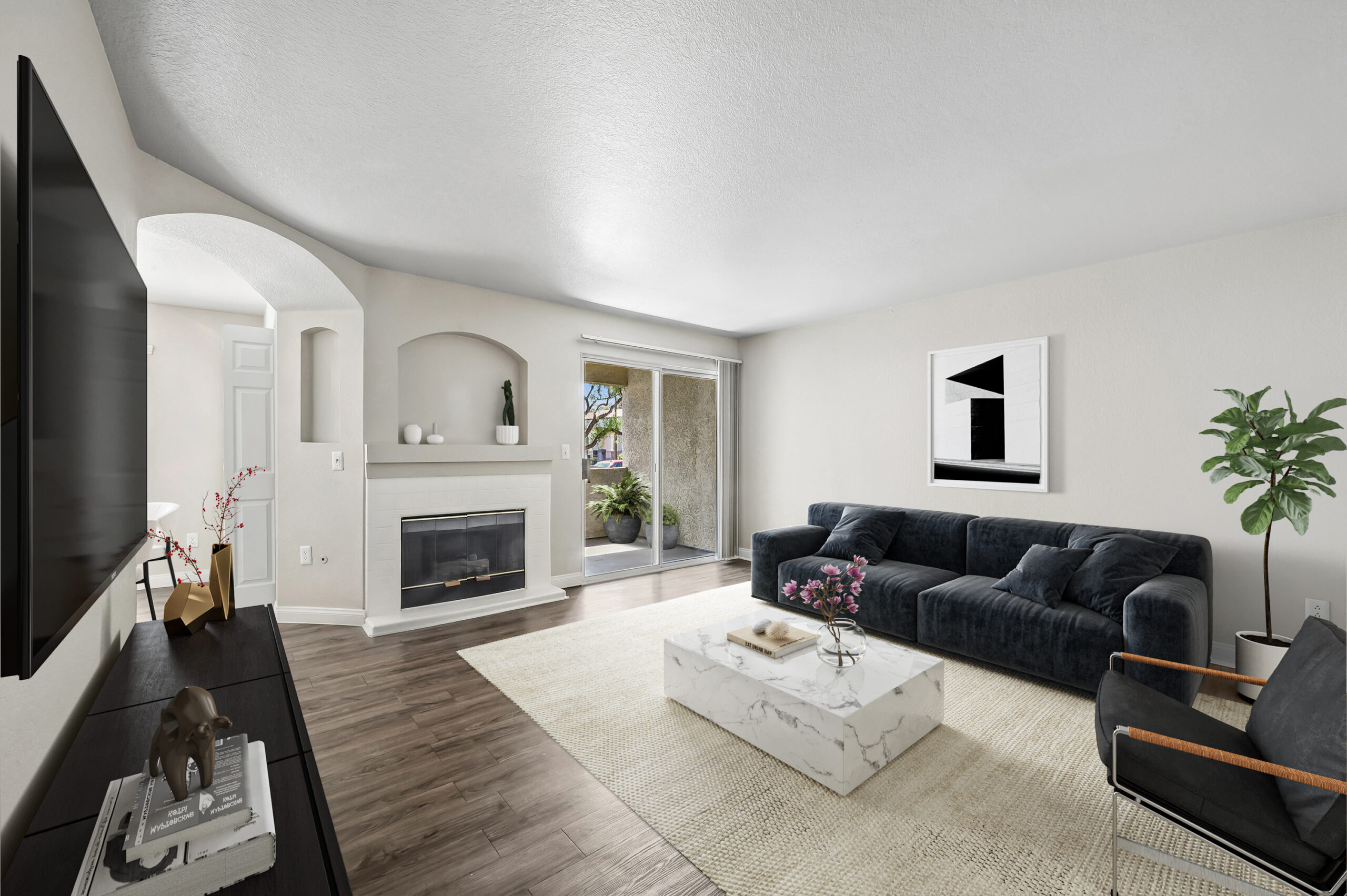 Modern apartment living room with wood-style flooring, fireplace, large windows, and sliding glass doors opening to a private patio.