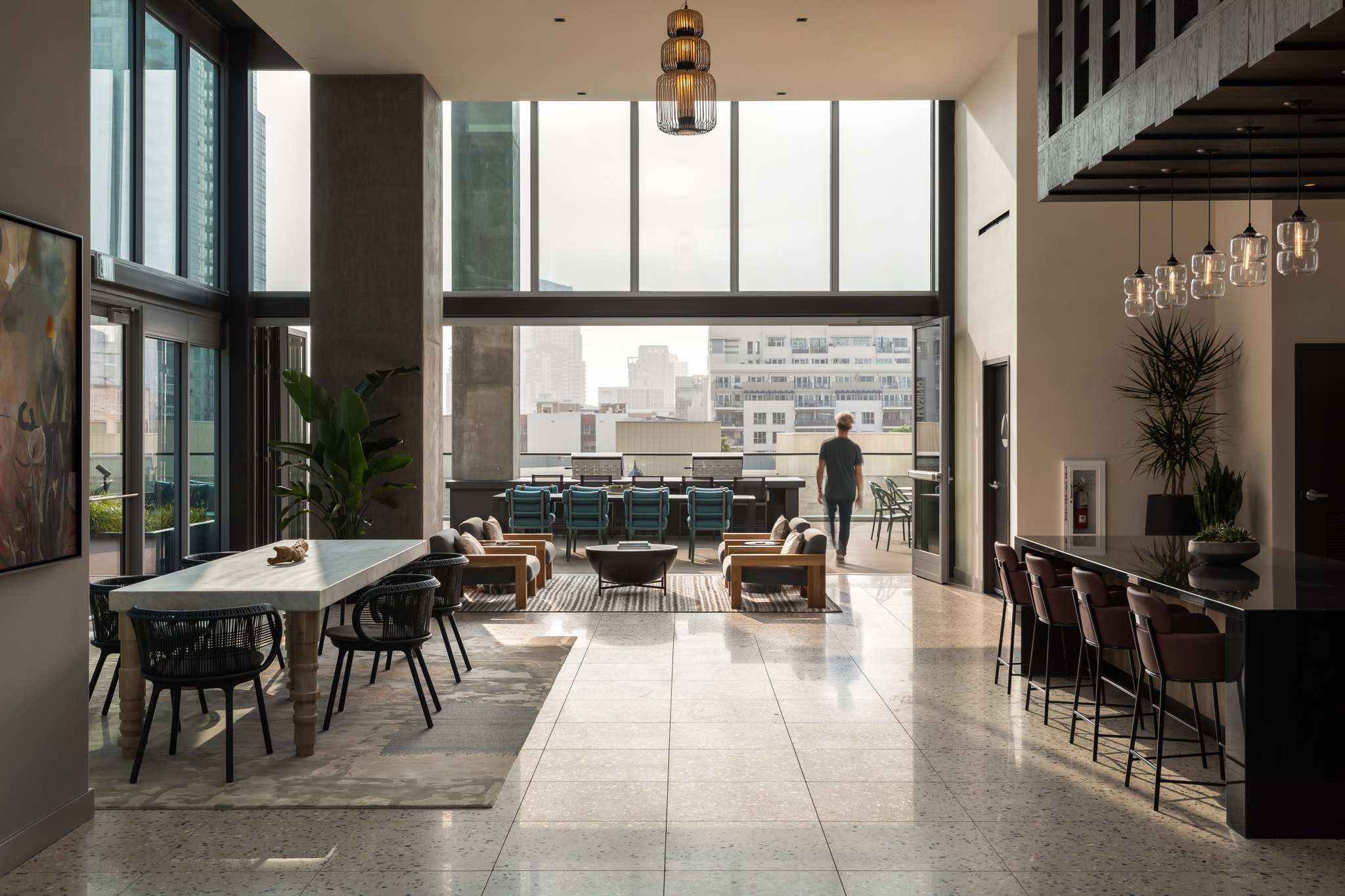 Lounge amenity with tables and a person looking out the window